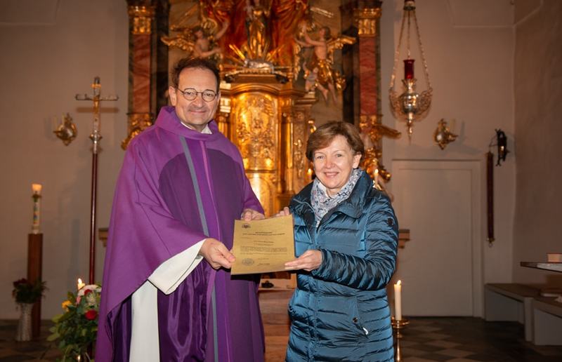 Vikar Gerhard Hatzmann überreicht das Dekret zur Wortgottesdienstleiterin an Christa Pichler